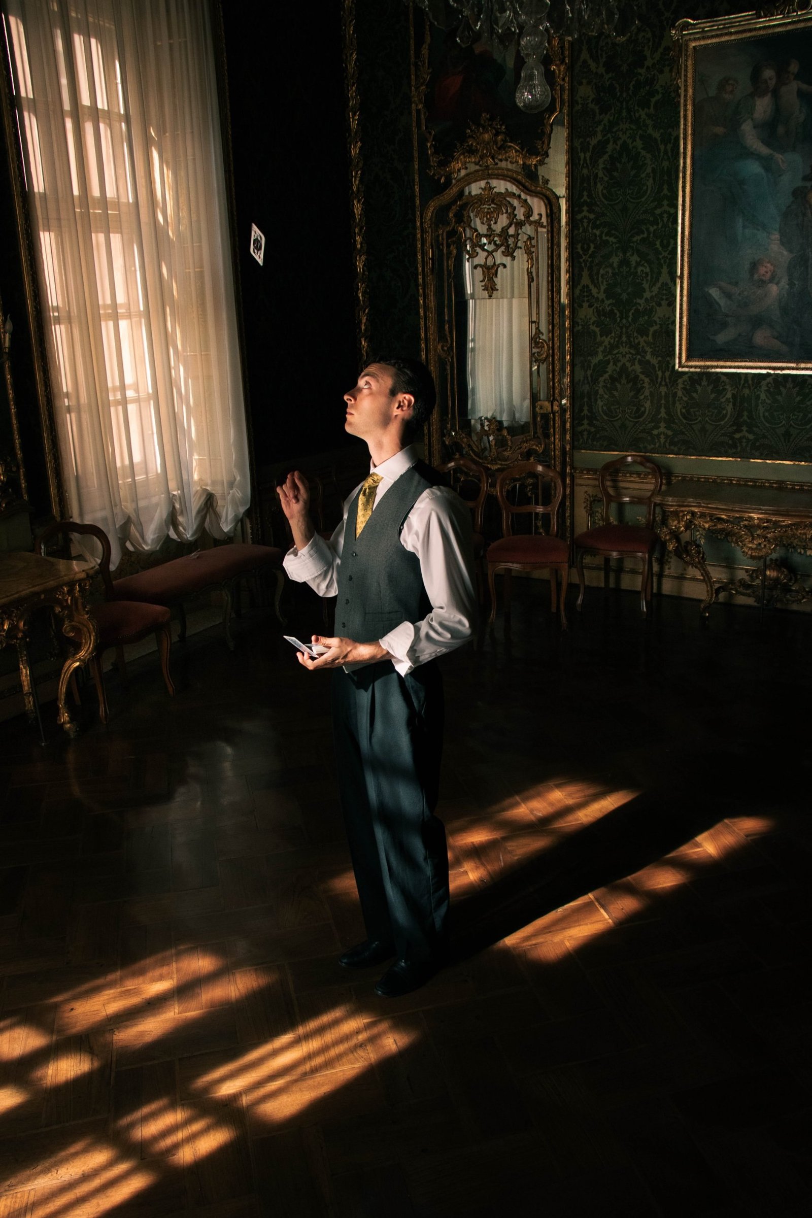Piero Venesia in piedi in una sala di Palazzo Barolo, mentre una carta resta sospesa in aria